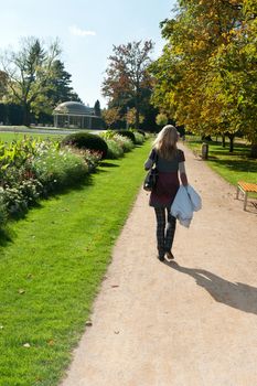 The girl goes down the avenue in a park near fantanov