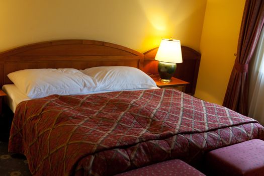 dressed with a red coverlet bed in hotel room