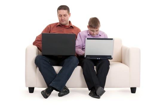 Father and son sitting on the couch with laptops