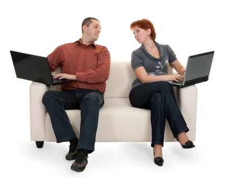 Husband and wife sitting on the couch with laptops