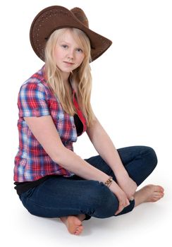 Beautiful girl in a cowboy hat sitting in the lotus position