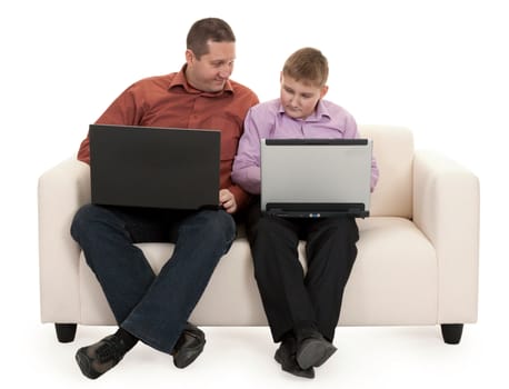 Father and son sitting on the couch with laptops