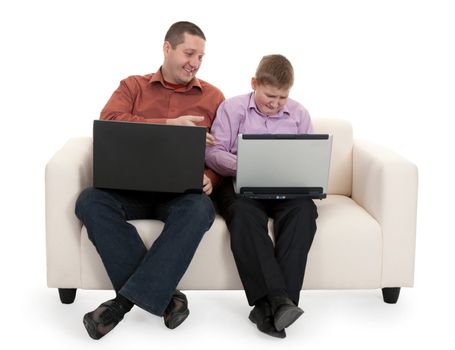 Father and son sitting on the couch with laptops