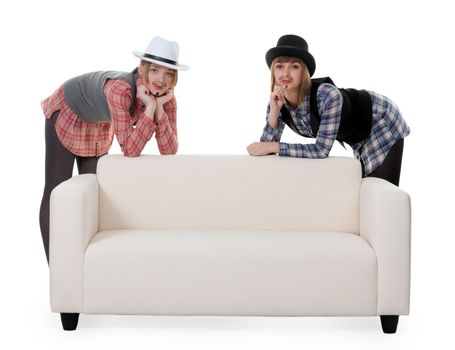 Two girls on the couch with a mustache painted on a white background