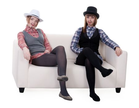 Two girls on the couch with a mustache painted on a white background