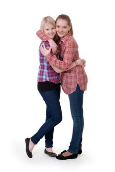 two girlfriends in checkered shirts hug on white background