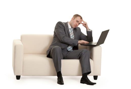 businessman with laptop on a couch on white background