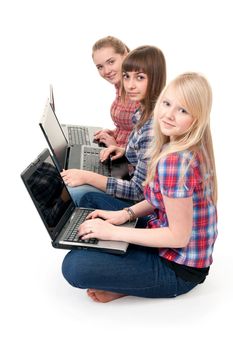 Three girls with laptops sitting in the lotus position
