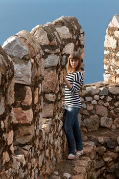 Beautiful girl on the wall of an old fortress