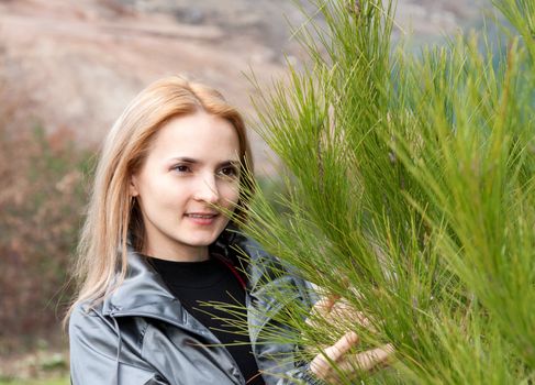 Portrait of a beautiful girl with a pine tree