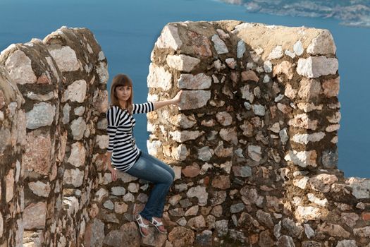Beautiful girl on the wall of an old fortress