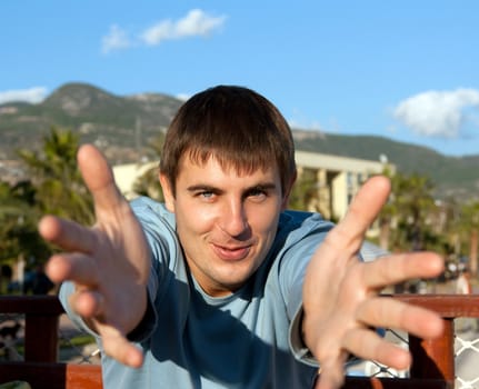 Portrait men on nature, pulls hands to spectator