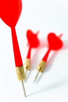 three red darts on a white surface