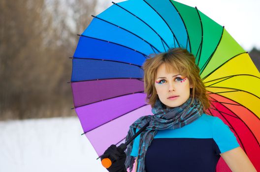 Young woman with multicolor umbrella at forest