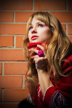 Fashion portrait of young woman on red brick wall background