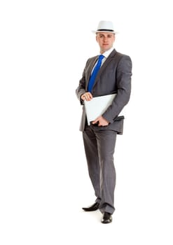Young businessman in a suit and a hat with a laptop