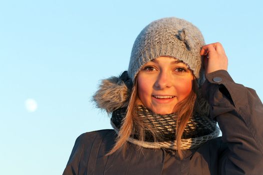portrait of a beautiful young girl in the sunlight in the cold