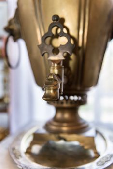 Spout of old russian bronze tea samovar. Selective focus on the front.