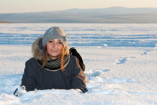 beautiful young girl rests in the snow