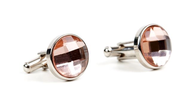 pair of platinum cufflinks with a pink stone isolated on white background