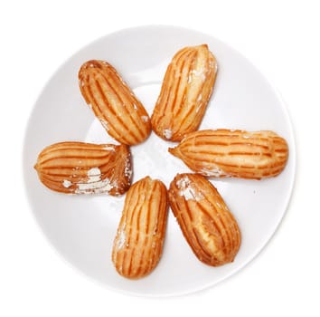Delicious eclairs arranged on a plate on a white background
