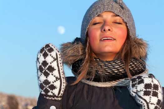 portrait of a beautiful young girl in the sunlight in the cold