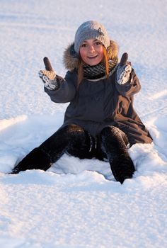 beautiful young girl sitting in the snow
