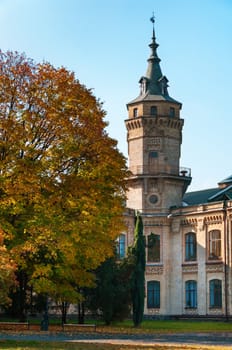 Vintage brick building in autumnal park with blue clean sky