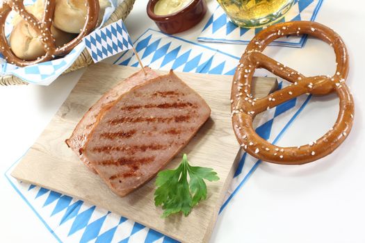 delicious Bavarian beef and pork loaf with pretzels and mustard on a light background