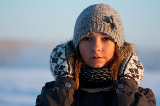 portrait of a beautiful young girl in the sunlight in the cold