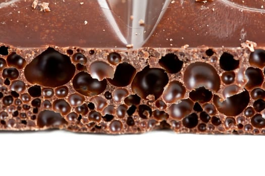 porous dark chocolate closeup on white background