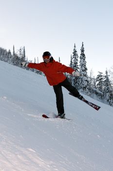 Man skiing in the orange jacket on the mountain