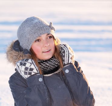 beautiful young girl sitting in the snow
