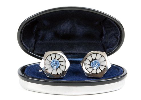 pair of platinum stud with topaz in an open casket isolated on white background