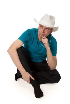 man in a cowboy hat sitting in the lotus position isolated on a white background