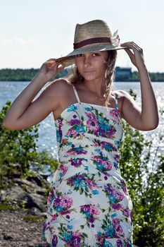 girl in a straw hat on the shore of Lake