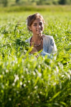 portrait of a beautiful girl in the green grass