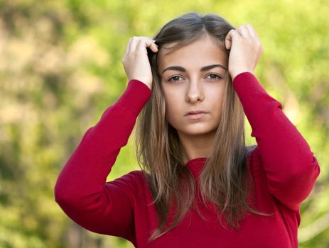 beautiful girl in a red jacket on a forest