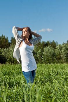 portrait of a beautiful young girl on green grass