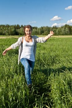 beautiful young girl goes on the green grass