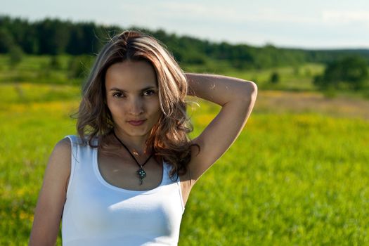 portrait of a beautiful young girl on a background of green grass
