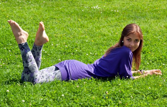 beautiful girl lying on green grass