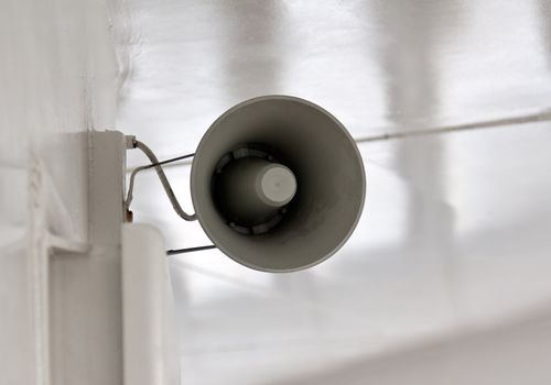 ship's megaphone on a white wall on the deck