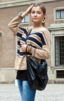 girl in beige sweater against the old facade