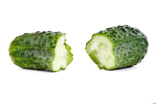 ripe cucumber is broken in half on a white background