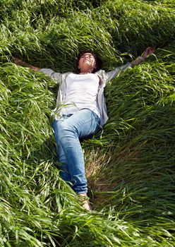 pin-up girl lying with her eyes closed in the green grass