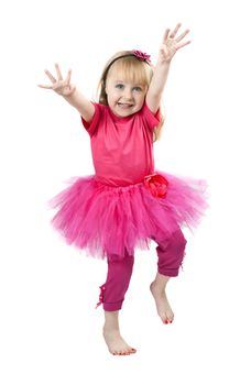 little girl in a pink dress dancing in studio isolated on a white background