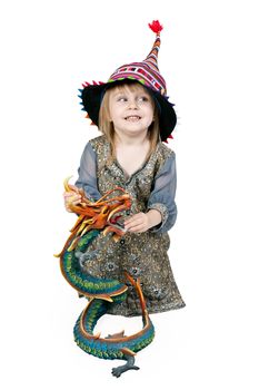 Little girl sitting on the floor with a decorative dragon in the studio on a white background 
