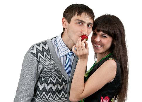 woman feeding man strawberries on a white background