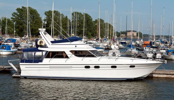 modern white high-speed boat in the port with sailing ships